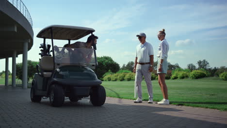 Golf-players-team-meeting-at-fairway-course.-Professionals-talk-sport-in-cart.
