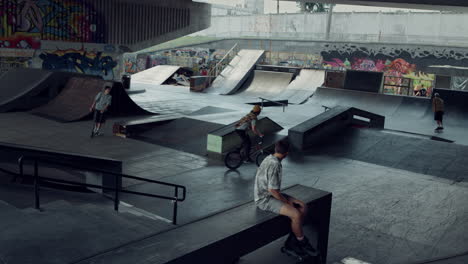 Sporty-teenagers-spending-time-together-at-urban-skate-park-with-graffiti.