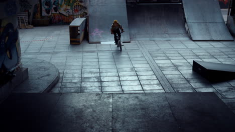 Teenage-bmx-rider-performing-dangerous-jump-stunt-on-ramp-at-skate-park.