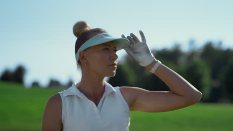 Attractive-golfer-look-game-match-at-course.-Woman-check-result-on-summer-field.