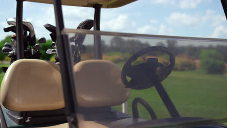Golf-cart-equipment-clubs-at-green-course.-Driving-car-stop-at-country-club.