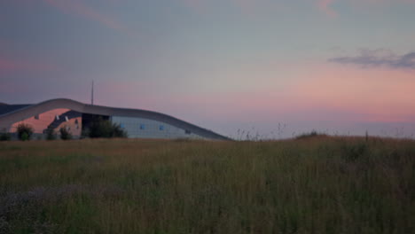 Wunderschöne-Rasenlandschaft,-Die-Durch-Ein-Großes-Gebäude-Wächst.-Sonnenuntergang-Naturhintergrund.