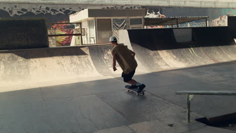 Skaterboarder-practicing-tricks-on-ramp-at-urban-skate-park.-Skater-carving-bowl