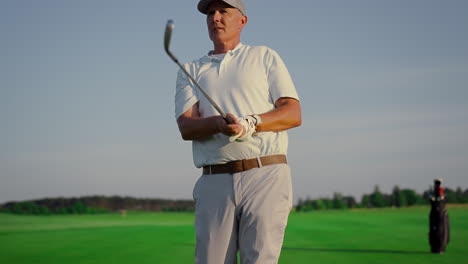 Golf-player-enjoy-hobby-on-green-course.-Old-man-watch-golfing-ball-on-fairway.