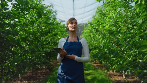 Woman-agronomist-checking-production-with-tablet-on-in-green-eco-farm-concept