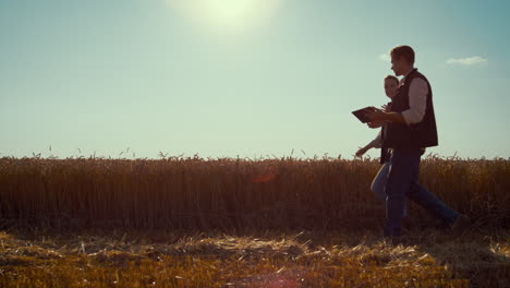 Agronomists-team-walking-wheat-field-on-sunny-day.-Summer-harvesting-season.