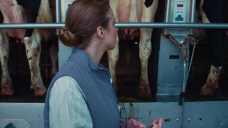 Woman-inspect-milking-equipment-hold-tablet-computer-in-modern-parlour-closeup.