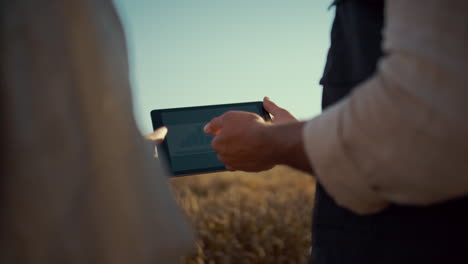 Farmer-hands-holding-pad-computer-closeup.-Agribusiness-team-checking-diagram.