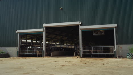 Dairy-farm-worker-walking-out-modern-manufacture-facility-at-countryside-alone.