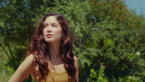 Cute-girl-posing-on-green-park-closeup.-Asian-woman-standing-on-sunlight-outdoor