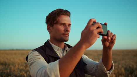 Man-taking-field-pictures-with-smartphone.-Focused-agricultural-worker-portrait.