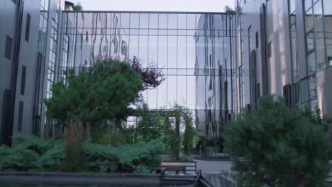 Gepflegter-Garten-Am-Glasgebäude-Im-Modernen-Innenstadtviertel.-Futuristisches-Äußeres.