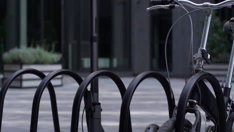 Closeup-electric-scooter-standing-at-shared-parking-together-with-black-bicycle.