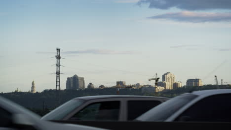 Evening-industrial-cityscape-at-blue-sunset-sky.-Speedy-cars-vehicles-driving.