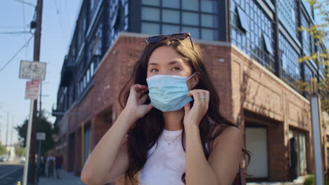 Pretty-girl-putting-mask-on-street.-Attractive-asian-woman-use-face-protection