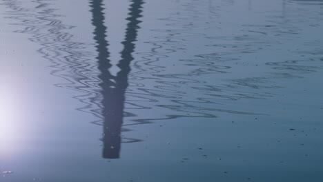 Lake-surface-reflect-bridge-autumn-day.-Silhouette-modern-tower-on-water.