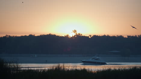 Moderner-Kutter,-Der-Den-Fluss-Bei-Sonnenuntergang-Segelt.-Sehen-Sie-Sich-Das-Schnellboot-In-Der-Abendlandschaft-An.
