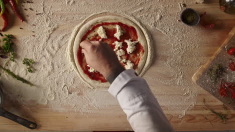 Man-making-homemade-pizza-pepperoni-italian-food-dinner-on-kitchen-table-board.