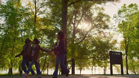 African-american-parents-holding-hands-walking-run-green-park-walkway-together.