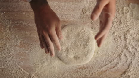 Chef-hands-cooking-kneading-dough-bread-in-italian-pizza-restaurant-kitchen.