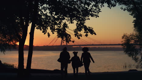 Happy-family-silhouette-run-to-river-hold-hands.-Beautiful-bridge-waterway-view.