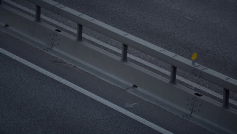 Cars-driving-evening-highway-big-city-drone-shot.-Freeway-modern-crash-barrier.