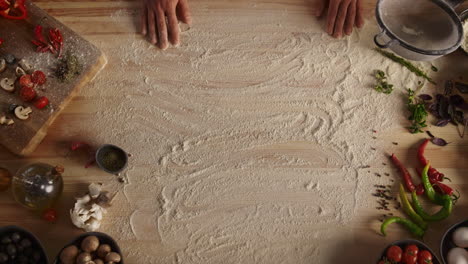 Chef-hand-preparing-flour-on-wooden-cutting-board-in-food-restaurant-kitchen.