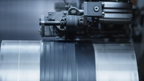 Closeup-tire-plant-automat-working-process-rotating-rubber-tape-automatically