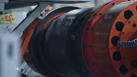 Detaillierte-Reifenproduktionstechnologie-Mit-Moderner-Orangefarbener-Maschine,-Die-Sich-In-Der-Fabrik-Bewegt