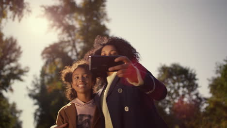 Sonriente-Madre-Hija-Filmando-Video-Selfie-Para-Cuenta-Social-Medial-En-El-Parque
