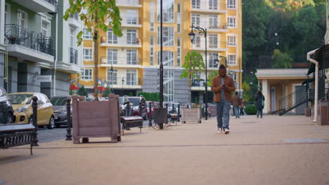 Hombre-Feliz-Caminando-Por-Las-Calles-De-La-Ciudad-Usando-Un-Teléfono-Inteligente.-Viajero-Urbano-Deambulando