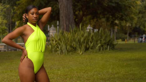 A-black-woman-stands-in-the-park-wearing-a-sexy-thong-bikini