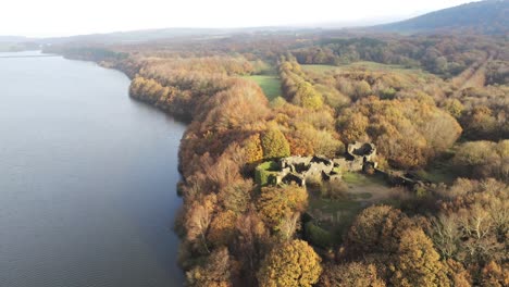 Liverpool-castle-replica-ruins-in-Autumn-Rivington-reservoir-woodland-nature-countryside-aerial-view-wide-orbit-right