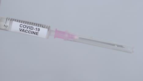 Hand-With-Glove-Removing-Needle-From-Syringe-For-Covid-19-Vaccine---close-up