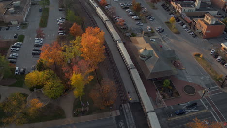 Aerial-drifting-over-a-passenger-train-parked-at-a-train-station-in-Kirkwood-in-St
