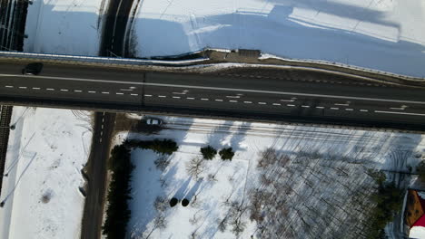Fahrzeug,-Das-Im-Winter-Auf-Asphaltstraße-Mit-Schneebedecktem-Feld-In-Der-Nähe-Von-Racowice,-Polen-Fährt