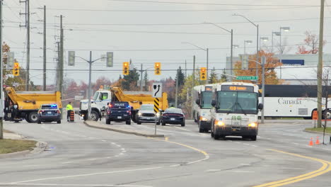 View-of-blocked-traffic-due-to-police-funeral,-buses-for-special-transport,-people-cross-the-road