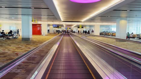 Walking-on-airport-walkway-tunnel-blue-lights-illumination