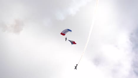 The-Texas-Flag-arrives-at-the-Wings-over-Houston-Airshow-in-2021-as-a-stunt-plane-races-by-in-the-background