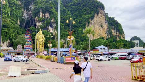 Shot-of-golden-statue-of-Hindu-God-Murugan-in-front-of-Subramanya-temple-along-Batu-Caves,-Malaysia