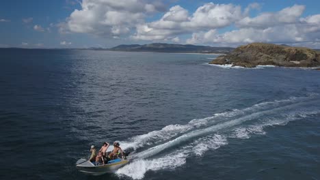 People-on-small-motorboat-along-coast-of-Emerald-beach,-Australia