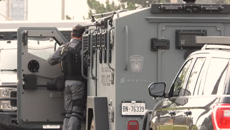 A-policeman-wearing-a-bulletproof-vest-and-uniform-gets-into-an-armored-car-in-a-motorcade-to-honor-the-memory-of-murdered-officer-Andrew-Hong