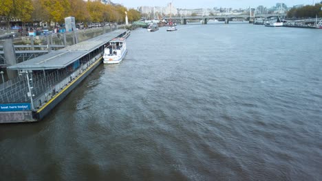 Disparo-En-ángulo-Alto-Sobre-El-Río-Támesis-Con-Lanchas-Motoras-Atracadas-A-Lo-Largo-De-La-Orilla-Del-Río-Con-La-Pasarela-Del-Milenio-En-Londres,-Reino-Unido-Durante-El-Día