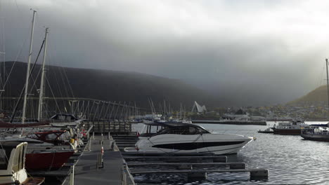 Yacht-Und-Boote-Im-Hafen-Von-Tromso-Mit-Arktischer-Kathedrale-Im-Hintergrund