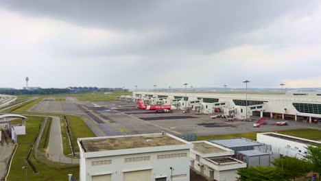 Toma-En-Gran-Angular-De-Un-Avión-De-Air-Asia-En-El-Aeropuerto-Internacional-De-Kuala-Lumpur-En-Malasiya-En-Un-Día-Lluvioso