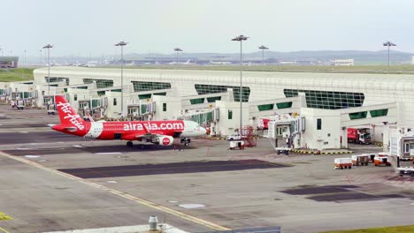 High-angle-shot-over-Air-Asia-plane-at-Kuala-Lumpur-International-Airport-on-a-cloudy-overcast-day