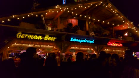 Shot-of-crowd-walking-around-the-street-of-winter-wonderland-in-London,-UK-at-night-time-with-roadside-food-stalls