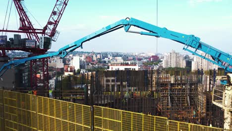 Aerial-view-over-a-construction-site-on-top-of-a-building-in-sunny-Brooklyn,-USA---reverse,-drone-shot