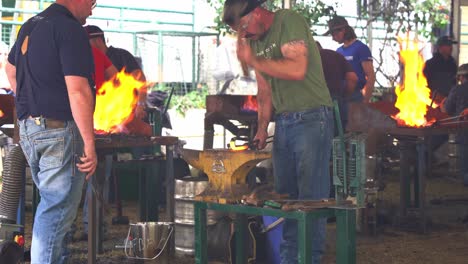 Artesanos-Herreros-Martillando-Duro-Para-Quemar-Metal-Caliente,-Forjando-Y-Dando-Forma-A-La-Pieza,-Elaborando-Herradura-En-La-Competencia-Agrícola-Anual-En-Ekka,-Espectáculo-Real-De-Queensland,-Ciudad-De-Brisbane