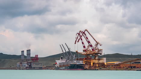 Raw-nickel-ore-being-unloaded-from-ships-for-processing-at-SLN-factory,-Noumea